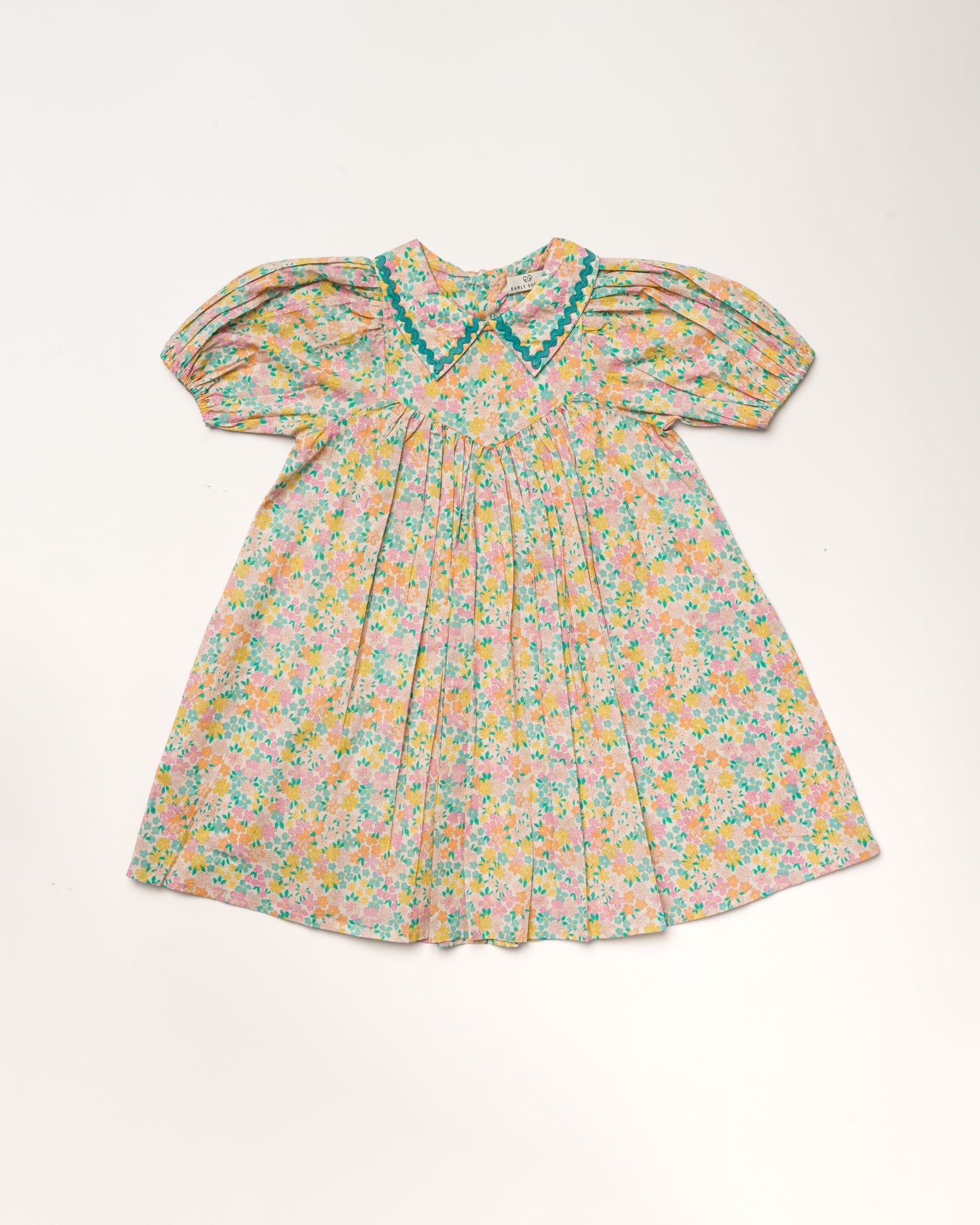 Early Sunday, Beth Dress in Emma Floral Mint color, made from printed cotton cambric fabric, featuring Puff sleeves, contrast scalloped collar for a vintage touch, shown in a front flat-lay view.