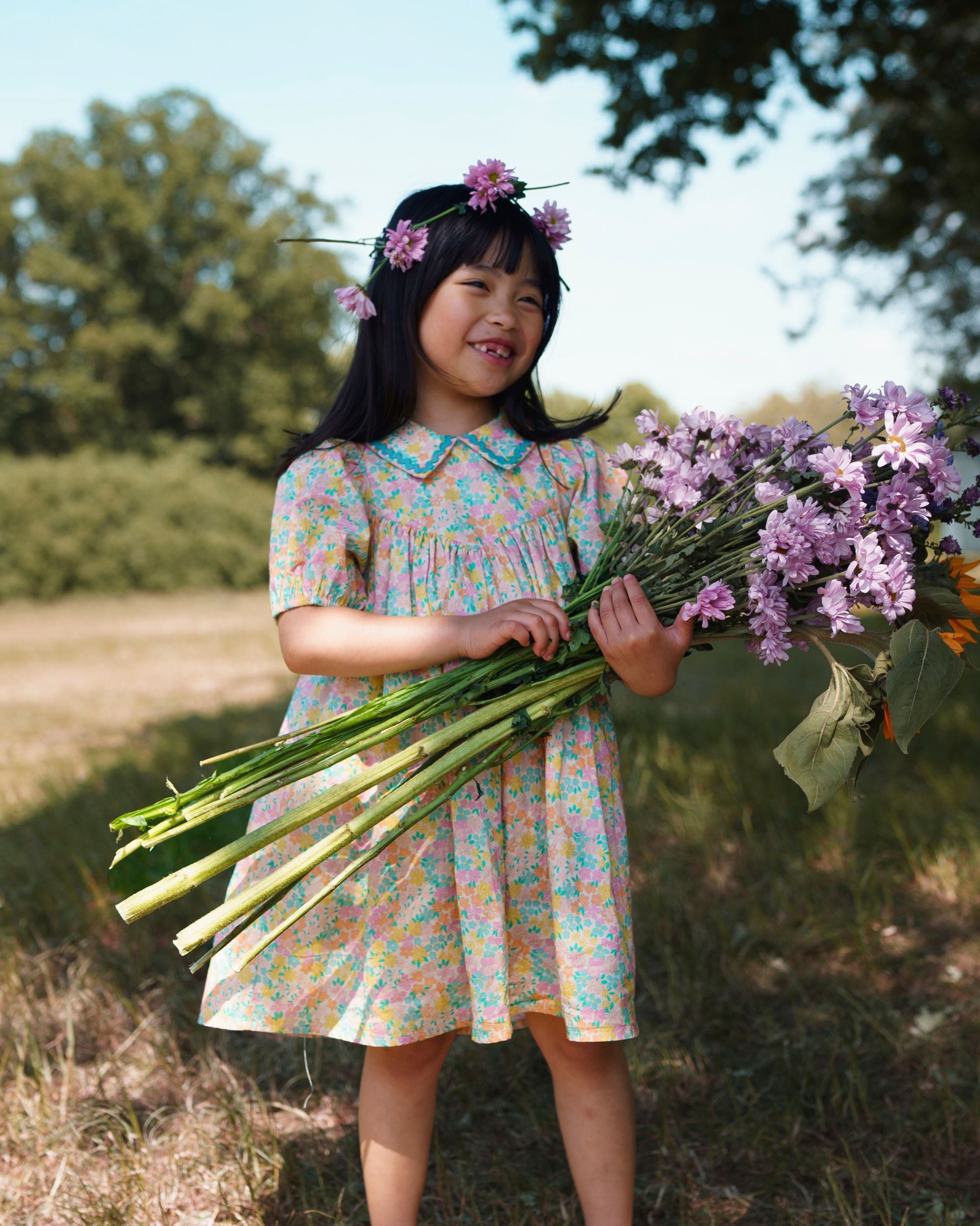 Early Sunday, Beth Dress in Emma Floral Mint color, made from printed cotton cambric fabric, featuring Puff sleeves, contrast scalloped collar for a vintage touch, shown in a model standing facing front wearing.