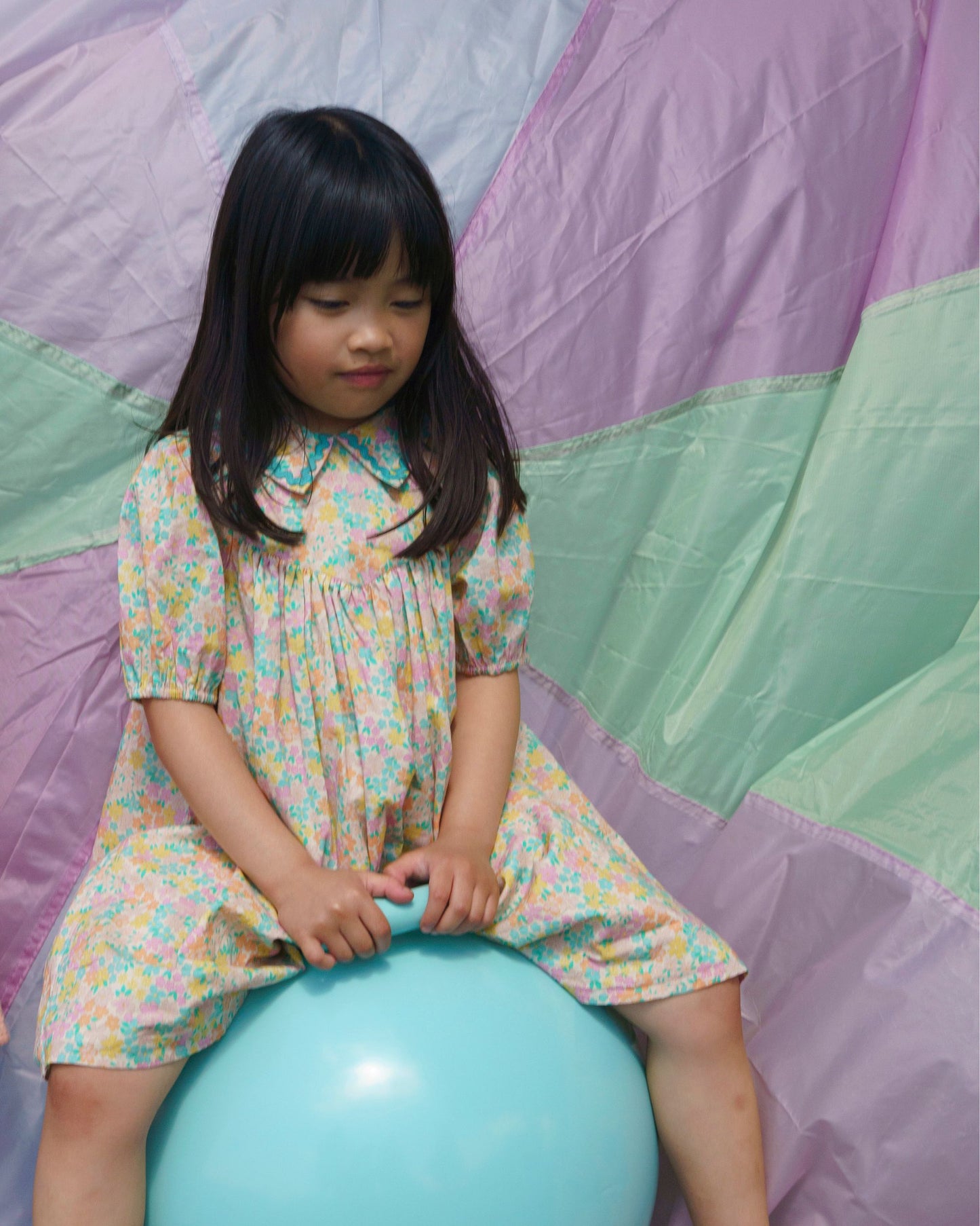 Early Sunday, Beth Dress in Emma Floral Mint color, made from printed cotton cambric fabric, featuring Puff sleeves, contrast scalloped collar for a vintage touch, shown in a model wearing outdoors.