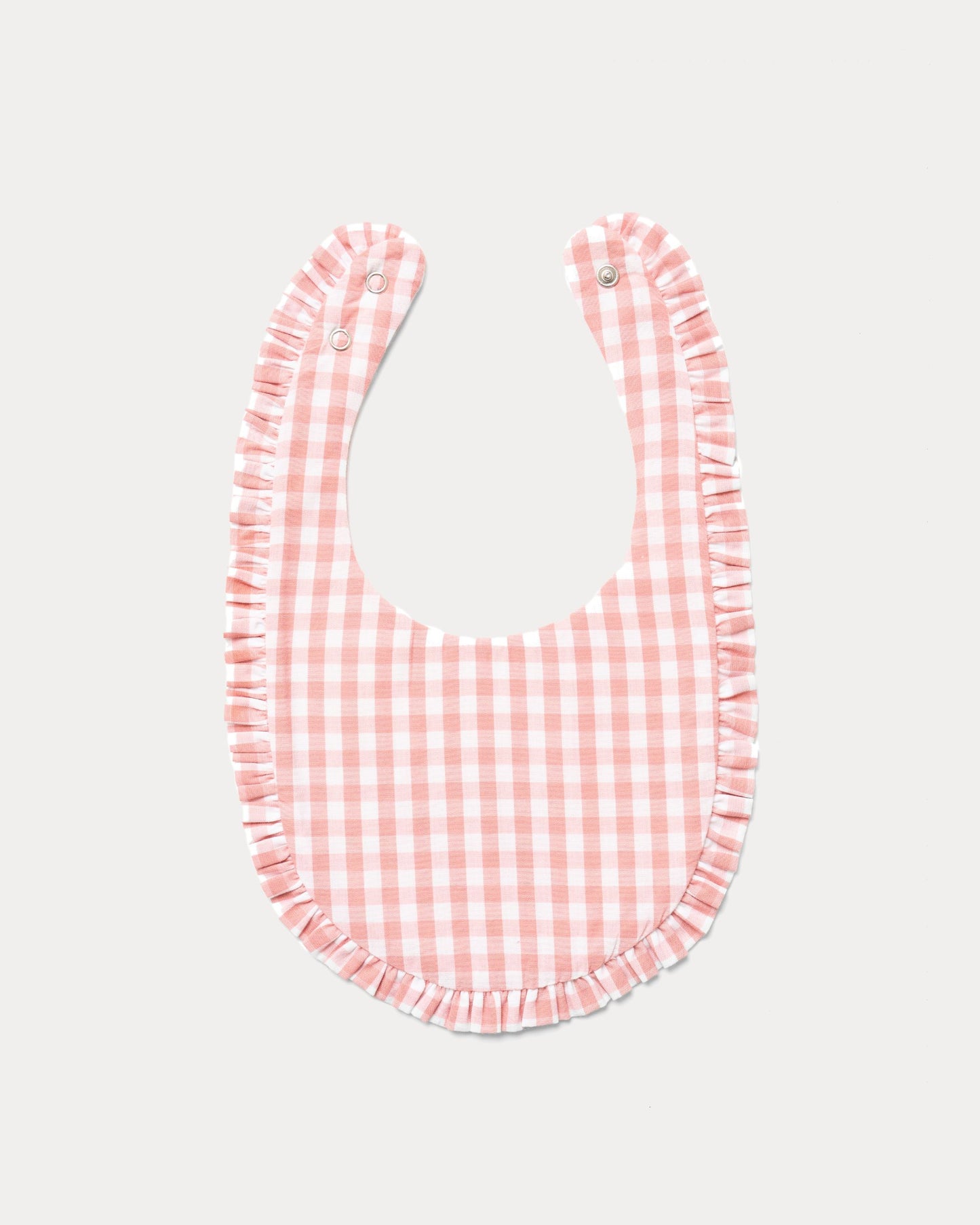 Early Sunday, Bib in Peony checks, made from Cotton Double Gauze fabric, shown in a back flat-lay view