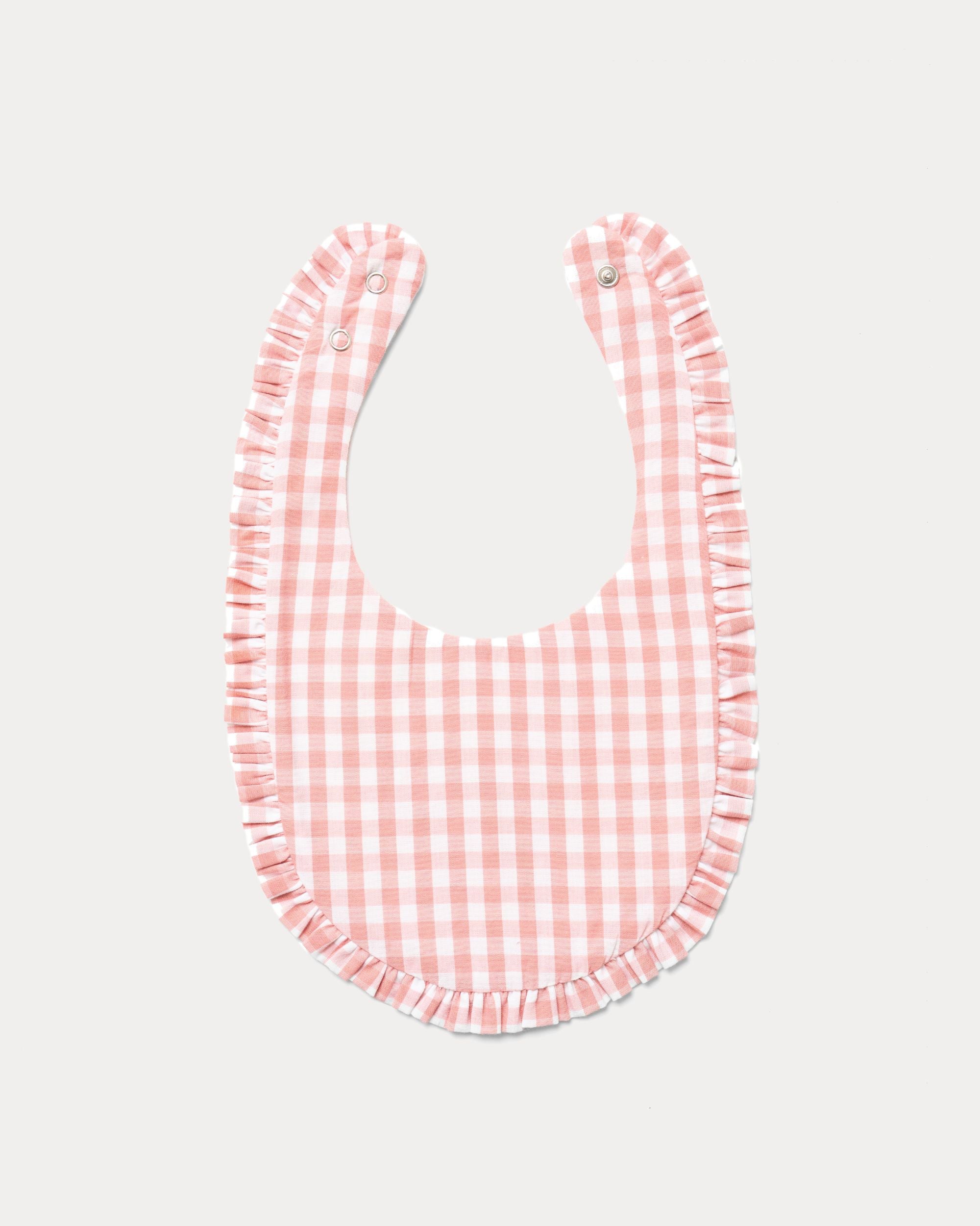 Early Sunday, Bib in Peony checks, made from Cotton Double Gauze fabric, shown in a back flat-lay view