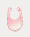Early Sunday, Bib in Peony checks, made from Cotton Double Gauze fabric, shown in a front flat-lay view