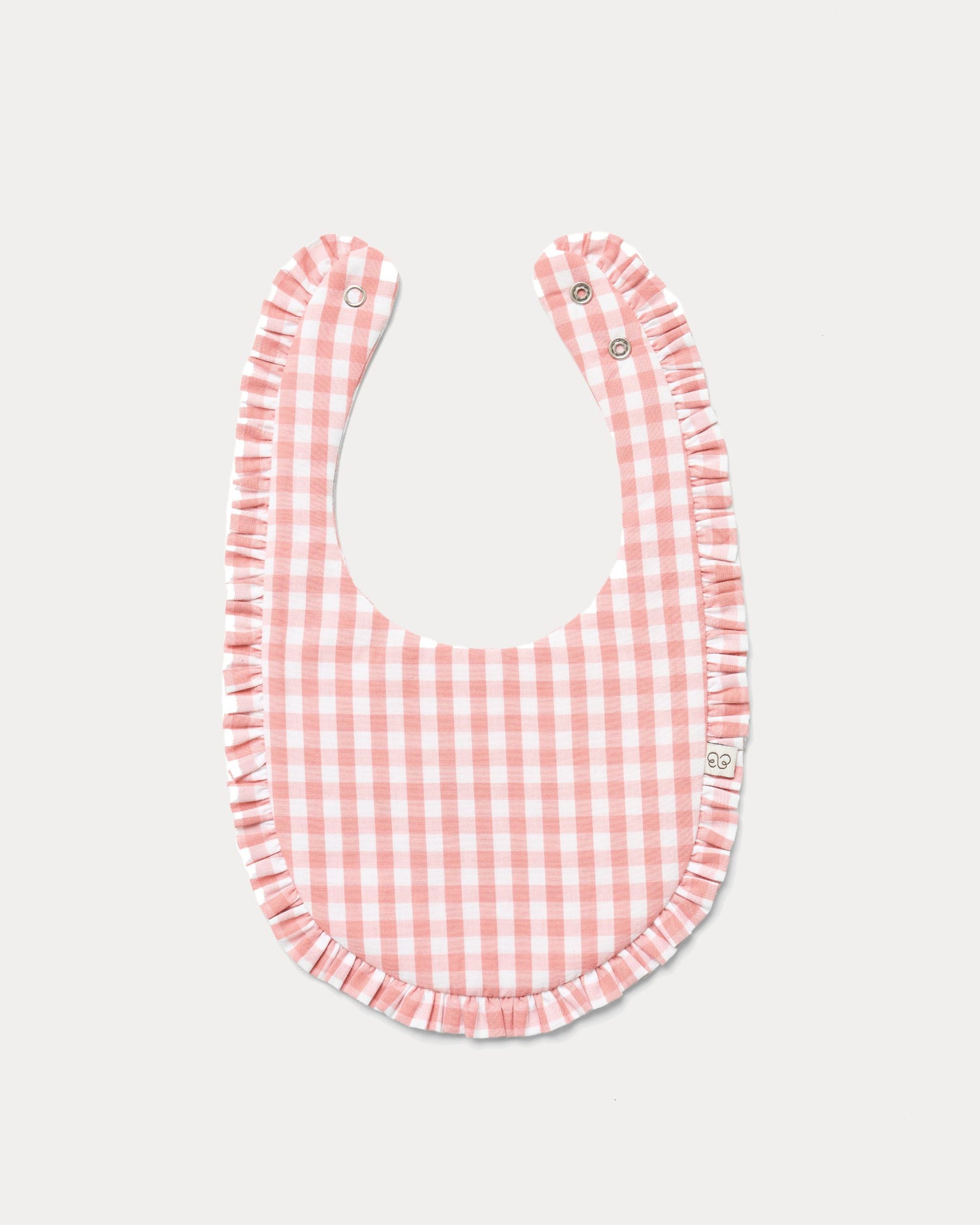 Early Sunday, Bib in Peony checks, made from Cotton Double Gauze fabric, shown in a front flat-lay view