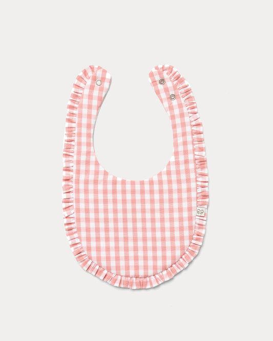 Early Sunday, Bib in Peony checks, made from Cotton Double Gauze fabric, shown in a front flat-lay view