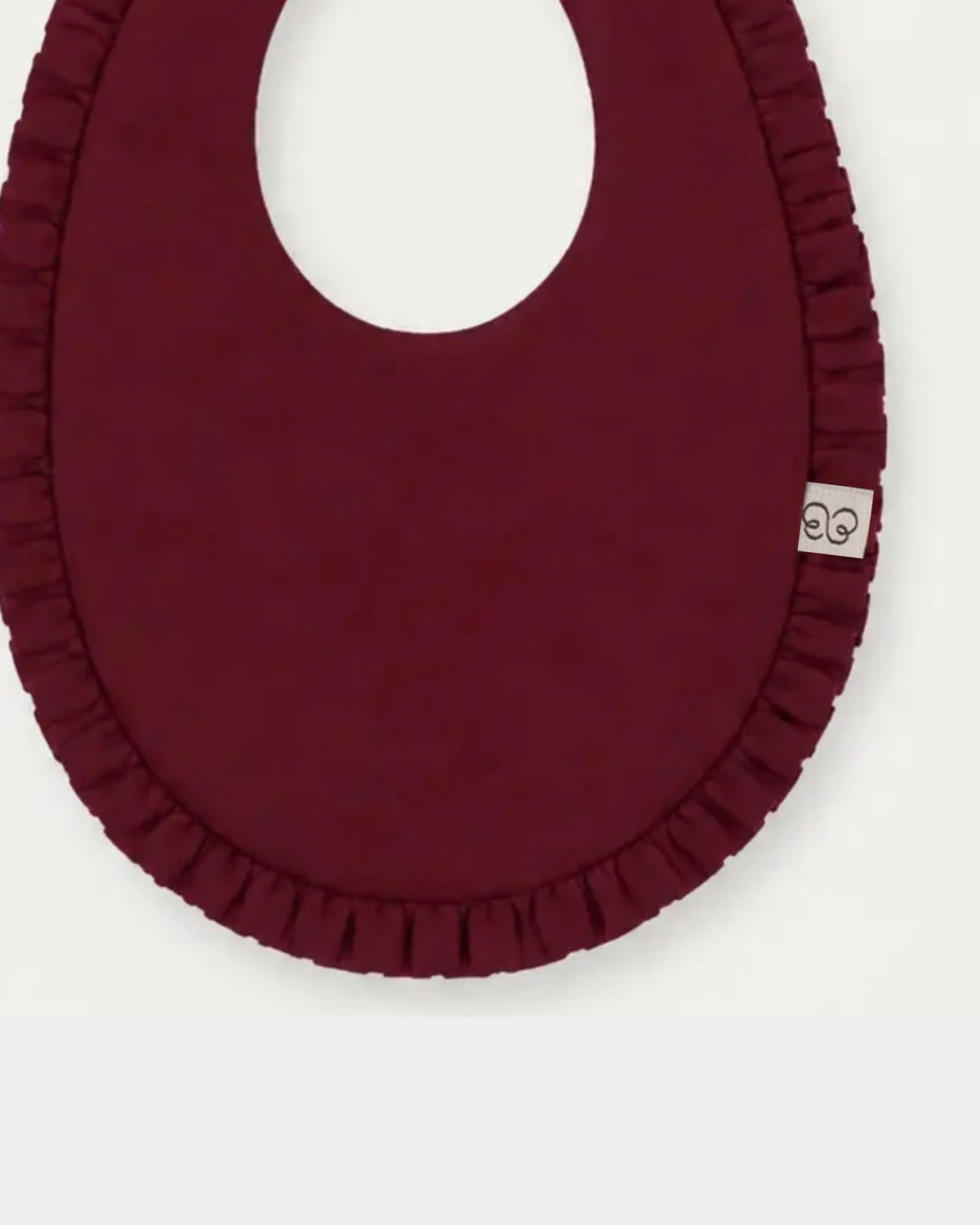 Early Sunday, Bib in Plum, made from Cotton Double Gauze fabric, featuring featuring a soft and comfortable design with an adjustable fit, shown in a closeup flat-lay view