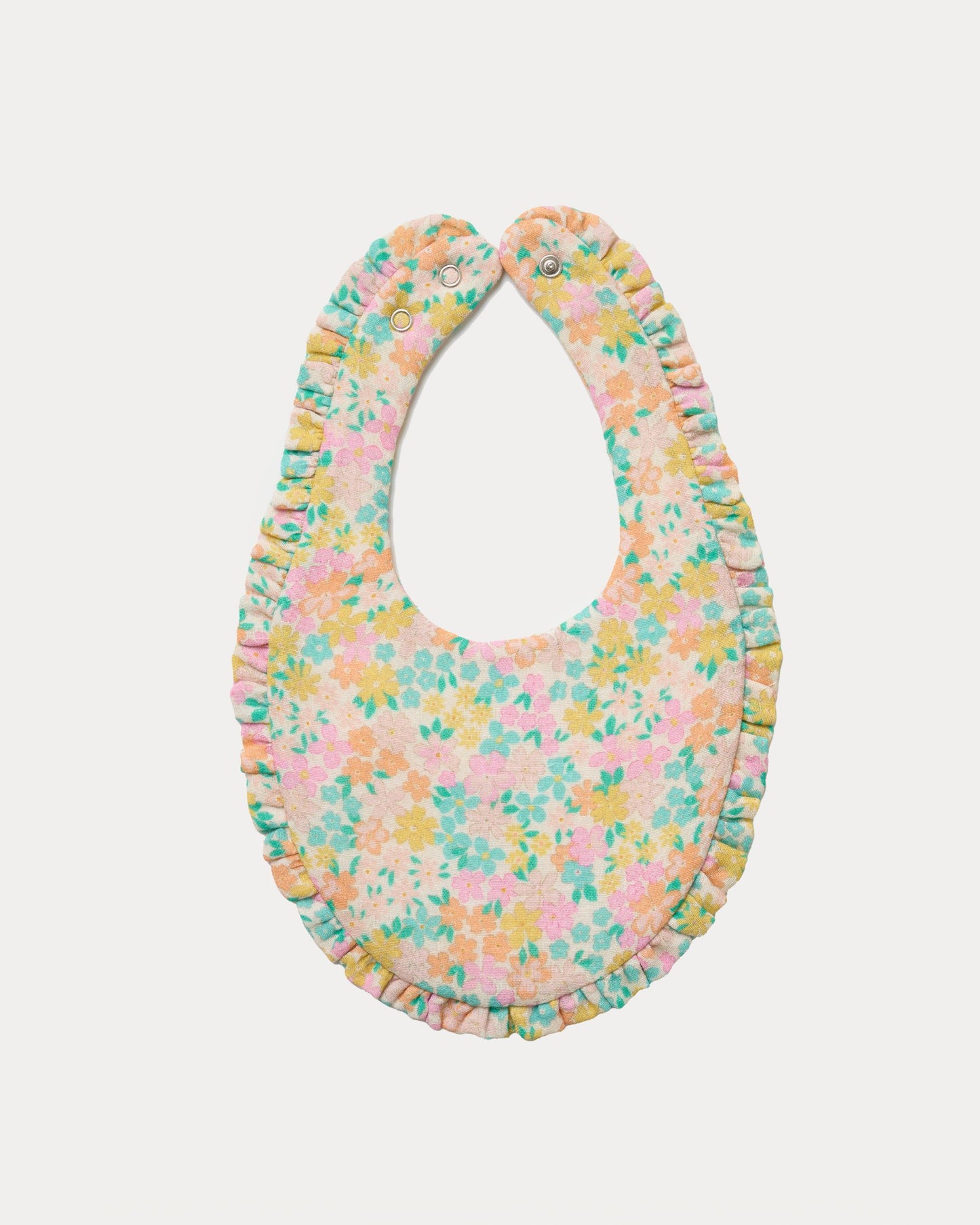 Early Sunday, Bib in Emma Floral Mint color, made from Organic Printed Cotton Double Gauze fabric, shown in a back flat-lay view