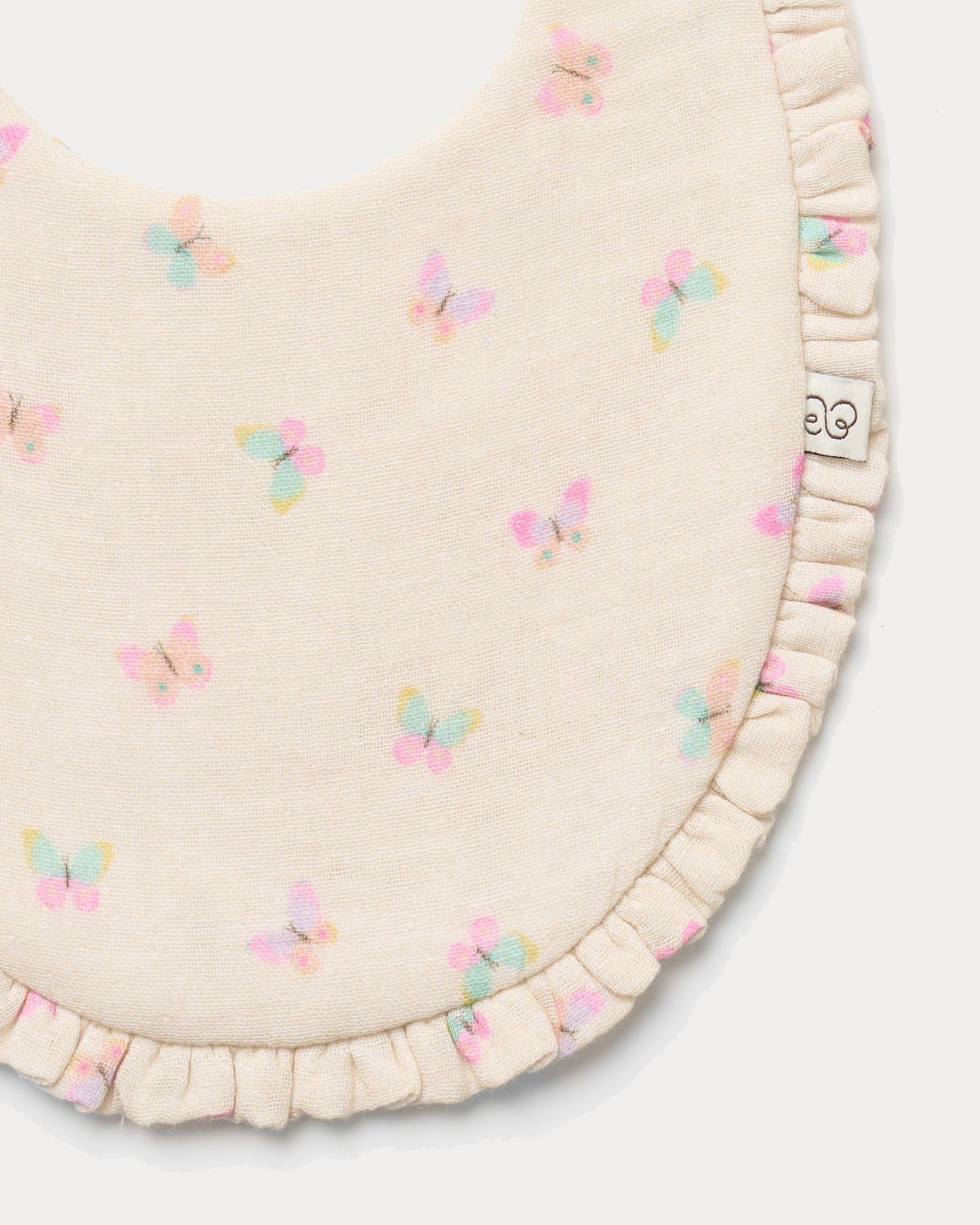 Early Sunday, Bib in Butterflies print, made from Printed Cotton Double Gauze fabric, shown in a closeup flat-lay view