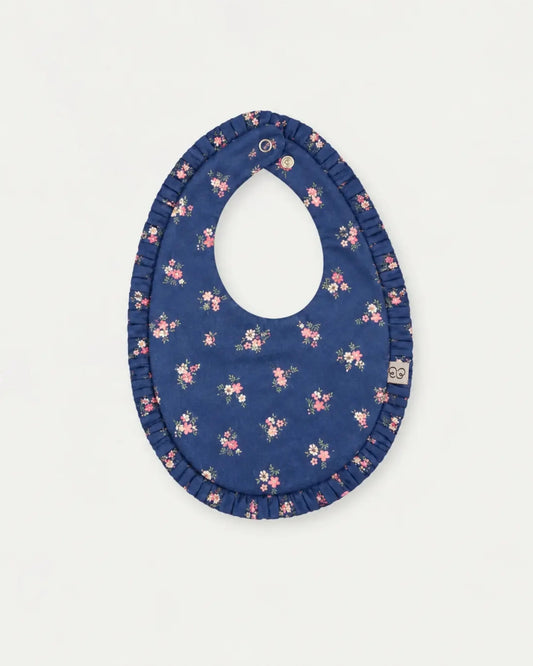 Early Sunday, Bib in Ditsy Bouquet Navy Blue, made from Printed Cotton Satin fabric, featuring a soft and comfortable design with an adjustable fit, shown in a front flat-lay view
