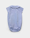 Early Sunday, Bobby Baby Romper in Summer Sky color, made from 100% Cotton Chambray fabric, featuring short sleeves with peter pan collar, shown in a back flat-lay view