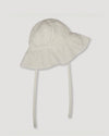Early Sunday, Bonnie Baby Sun Hat in Ivory color, made from All-Over Eyelet Embroidered Cotton Schifflie fabric, featuring wide brim for sun protection, designed to be lightweight and comfortable for all-day wear, shown in a front flat-lay view