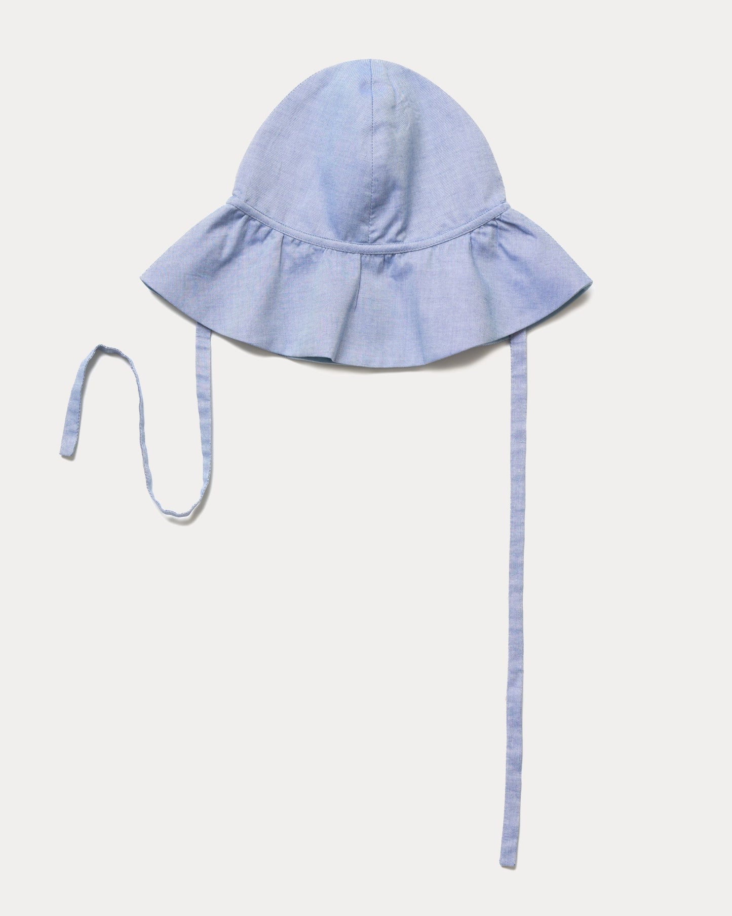 Early Sunday, Bonnie Hat Cap in Summer Sky color, made from Chambray fabric, shown in an angled view with wide brim and tie straps