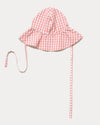 Early Sunday, Bonnie Hat Cap in Peony color, made from Gingham Check fabric, shown in an angled view with wide brim and tie straps
