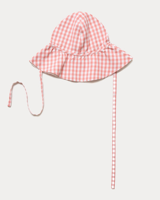 Early Sunday, Bonnie Hat Cap in Peony color, made from Gingham Check fabric, shown in an angled view with wide brim and tie straps