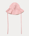 Early Sunday, Bonnie Hat Cap in Peony color, made from Gingham Check fabric, shown in a front flat-lay view with wide brim and tie straps
