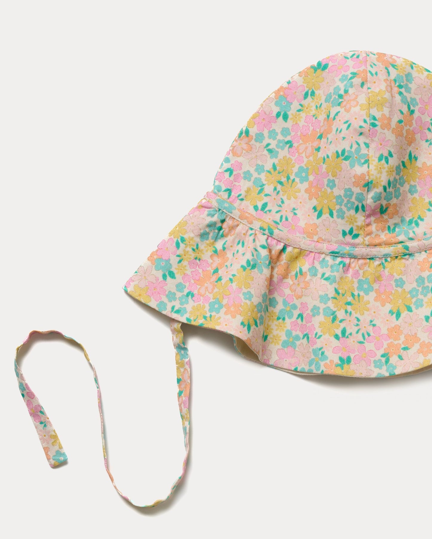 Early Sunday, Bonnie Hat Cap in Emma Floral Mint color, made from Organic Printed Cotton Cambric fabric, shown in a closeup flat-lay view