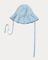 Early Sunday, Bonnie Hat Cap in Tonal Floral Blue color, made from Printed Tiny Swiss Dobby fabric, shown in an angled view with wide brim and tie straps