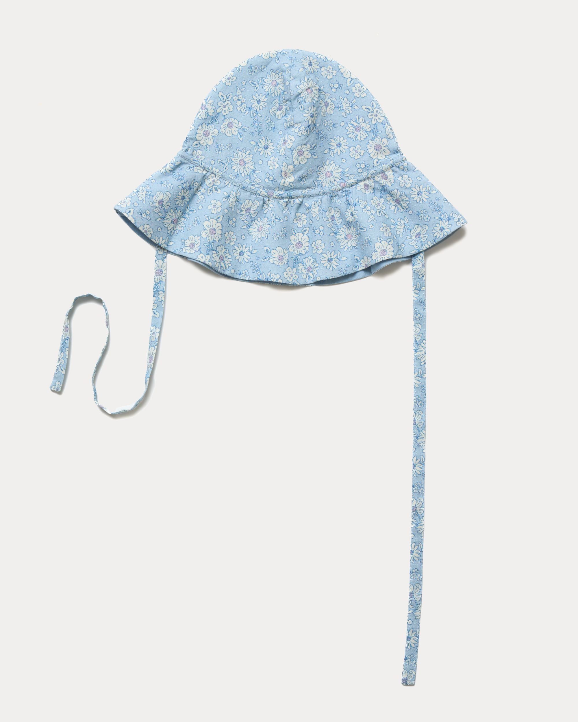 Early Sunday, Bonnie Hat Cap in Tonal Floral Blue color, made from Printed Tiny Swiss Dobby fabric, shown in an angled view with wide brim and tie straps