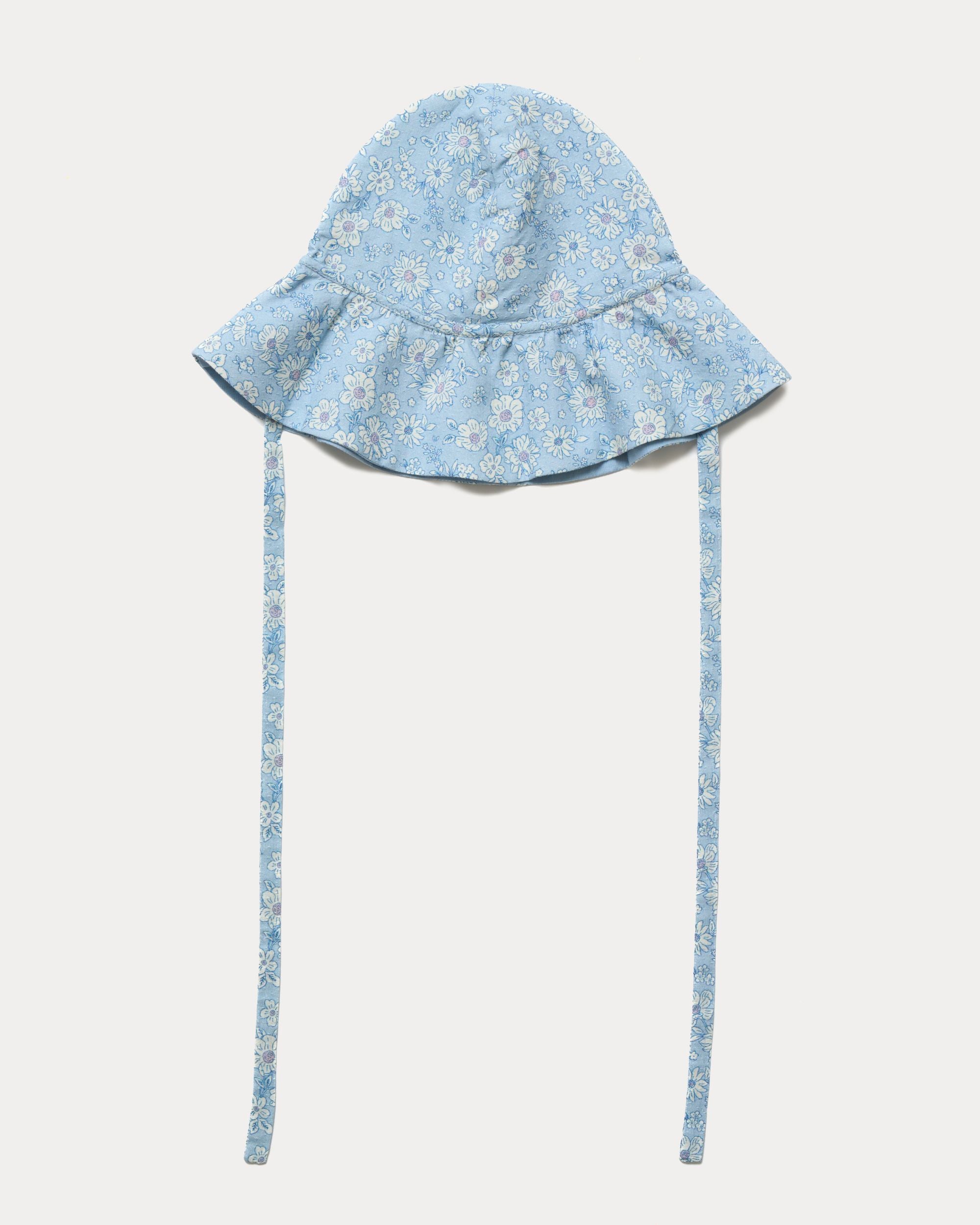 Early Sunday, Bonnie Hat Cap in Tonal Floral Blue color, made from Printed Tiny Swiss Dobby fabric, shown in a front flat-lay view with wide brim and tie straps