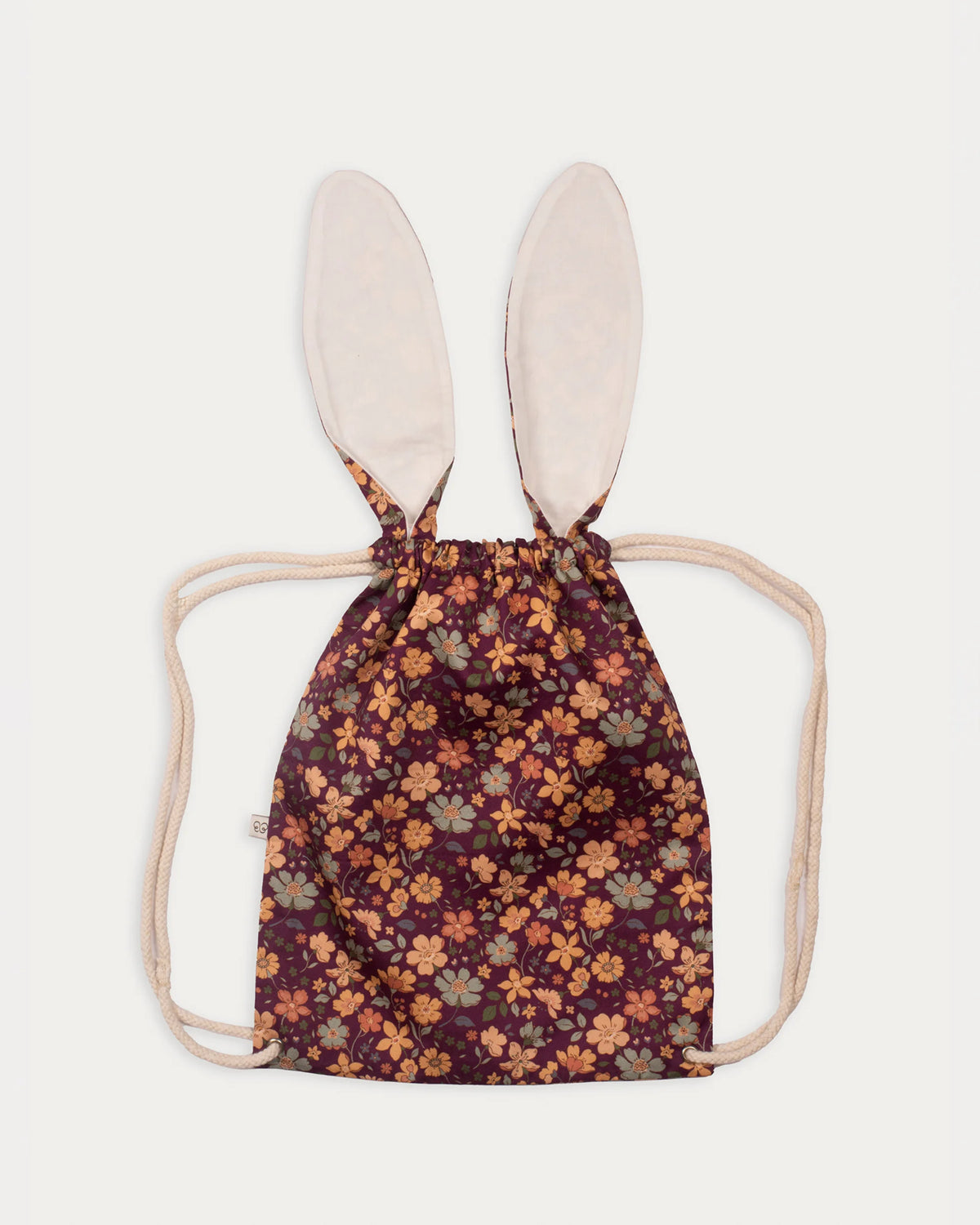 Early Sunday, Bunny Bag in Garden Flowers Plum, made from Printed Cotton Satin fabric, featuring a bunny-ear design with a drawstring closure, shown in a back flat-lay view