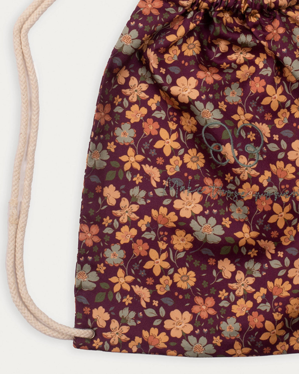 Early Sunday, Bunny Bag in Garden Flowers Plum, made from Printed Cotton Satin fabric, featuring a bunny-ear design with a drawstring closure, shown in a closeup flat-lay view