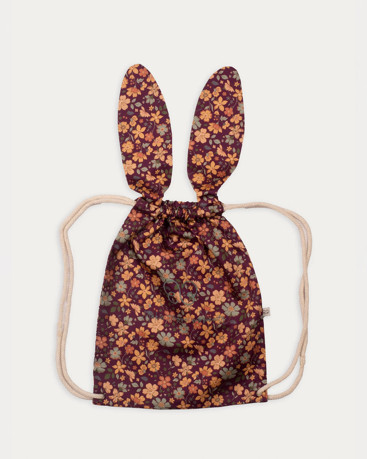 Early Sunday, Bunny Bag in Garden Flowers Plum, made from Printed Cotton Satin fabric, featuring a bunny-ear design with a drawstring closure, shown in a front flat-lay view
