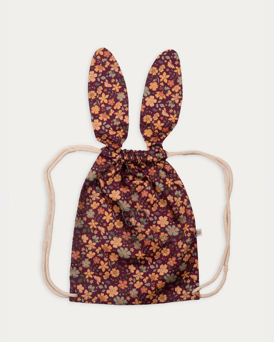 Early Sunday, Bunny Bag in Garden Flowers Plum, made from Printed Cotton Satin fabric, featuring a bunny-ear design with a drawstring closure, shown in a front flat-lay view