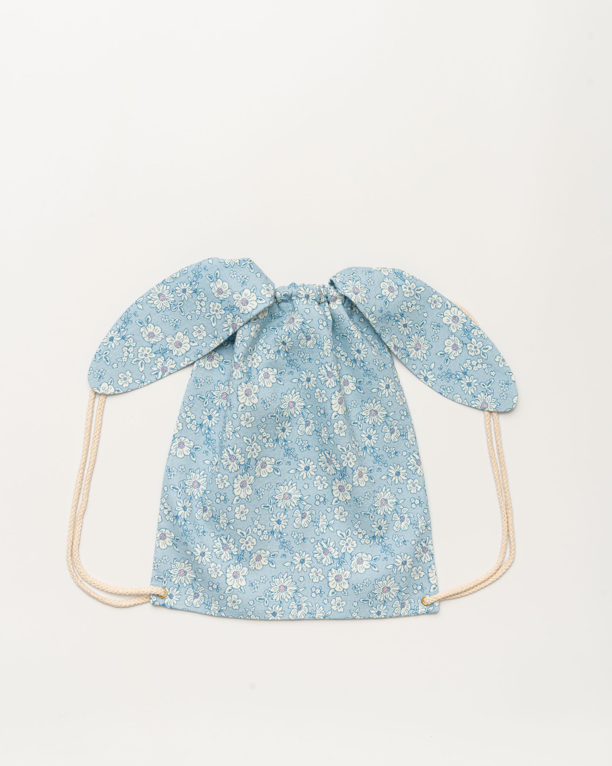 Early Sunday, Bunny Drawstring Backpack in Tonal Floral Blue color, made from Printed Cotton Tiny Swiss Dobby fabric, featuring a bunny-ear design with a drawstring closure, shown in a back flat-lay view