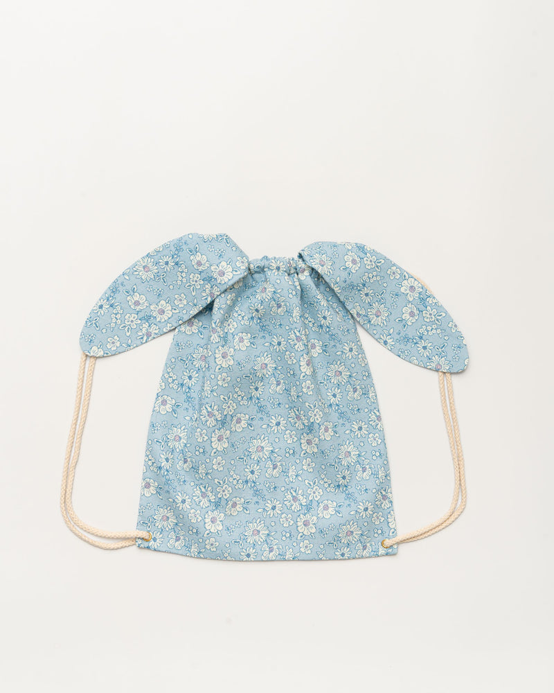 Early Sunday, Bunny Drawstring Backpack in Tonal Floral Blue color, made from Printed Cotton Tiny Swiss Dobby fabric, featuring a bunny-ear design with a drawstring closure, shown in a back flat-lay view