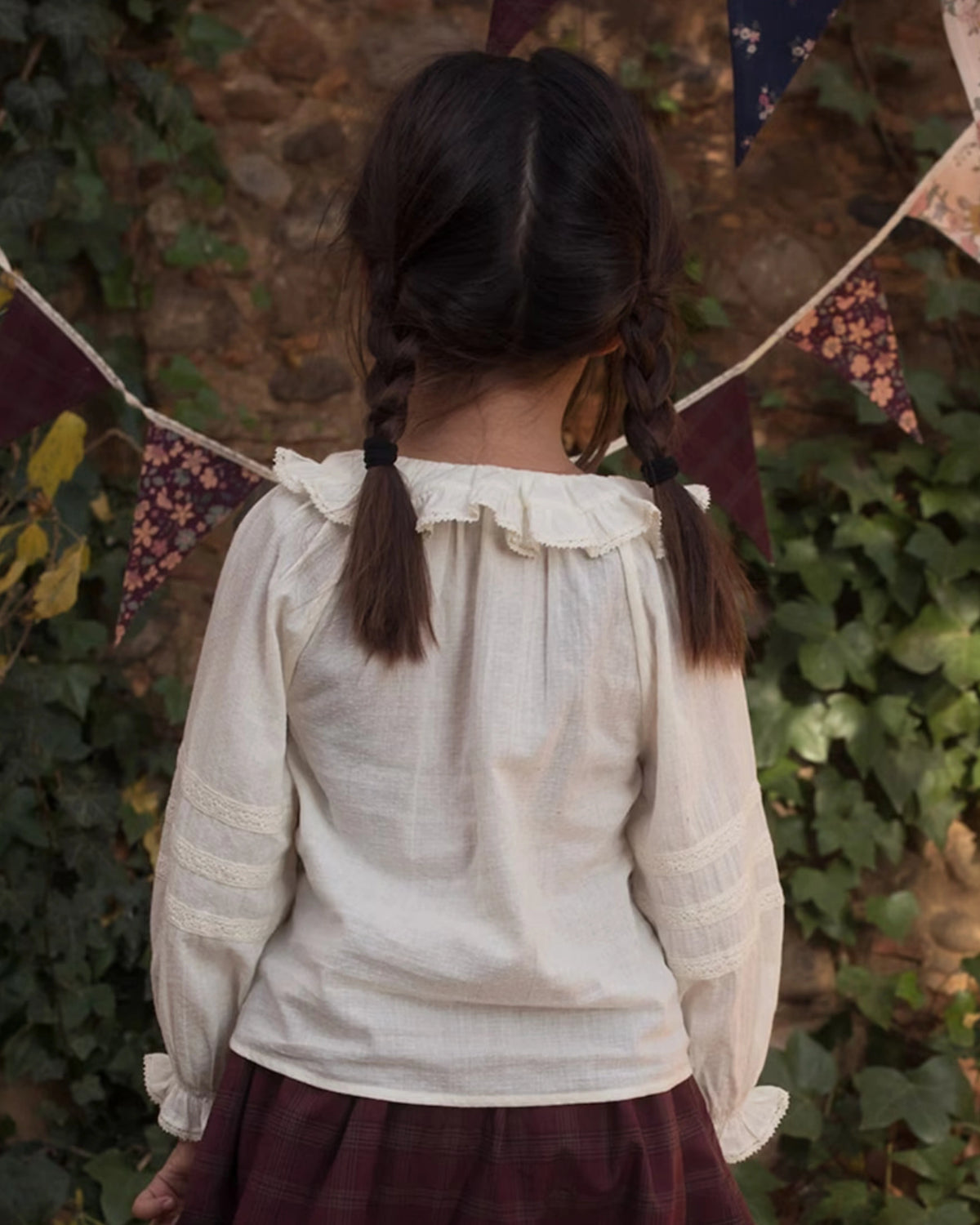 Early Sunday, Cécile Blouse in Ecru, made from Cotton Swiss Dobby fabric, featuring a relaxed silhouette with gathered sleeves and delicate detailing, shown in a back view of model wearing outdoors