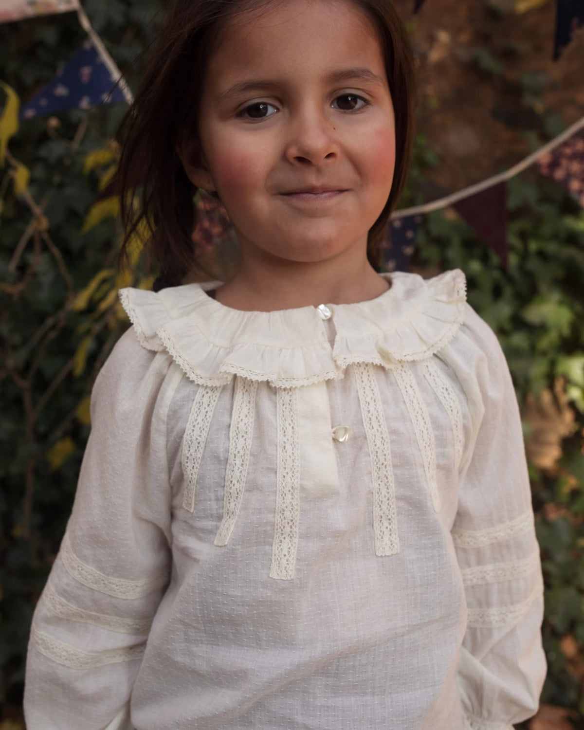 Early Sunday, Cécile Blouse in Ecru, made from Cotton Swiss Dobby fabric, featuring a relaxed silhouette with gathered sleeves and delicate detailing, shown in a close up shot of model wearing outdoors