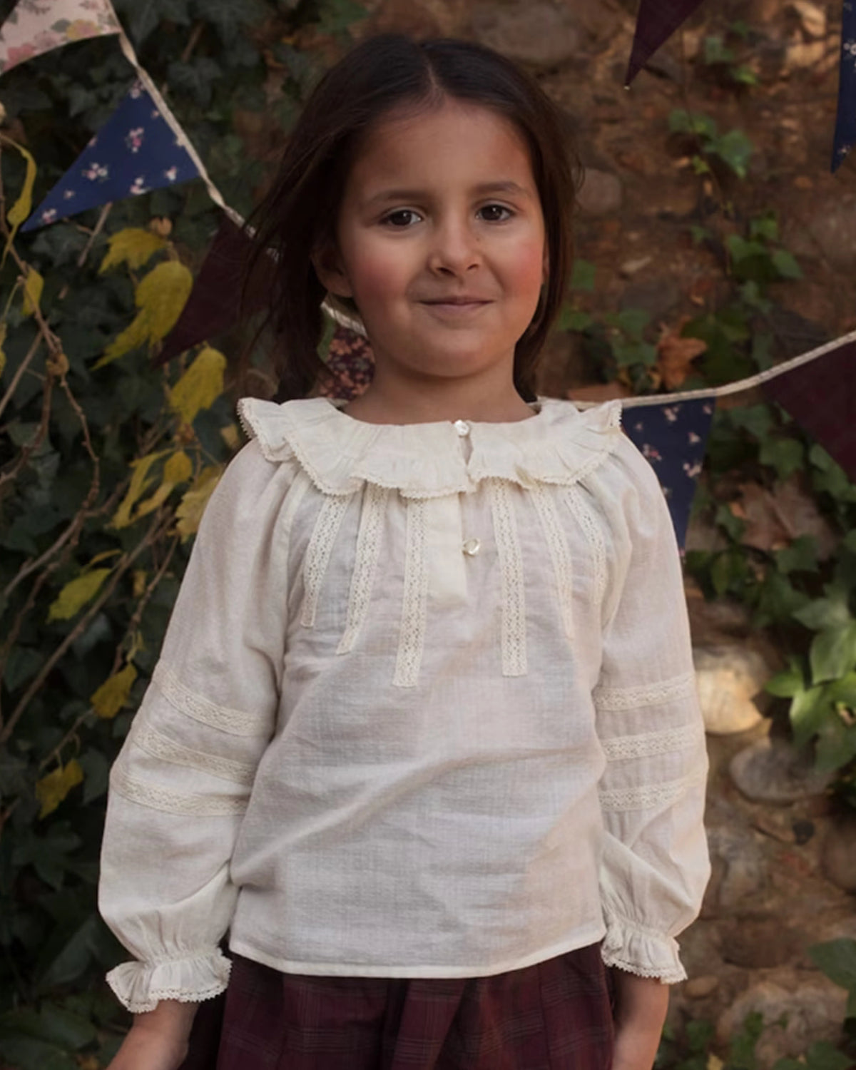 Early Sunday, Cécile Blouse in Ecru, made from Cotton Swiss Dobby fabric, featuring a relaxed silhouette with gathered sleeves and delicate detailing, shown in a front view of model wearing outdoors