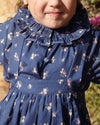 Early Sunday, Cécile Blouse in Ditsy Bouquet Navy, made from Printed Cotton Satin fabric, featuring a relaxed silhouette with gathered sleeves and delicate detailing, shown in a close up shot of model wearing it
