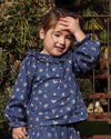 Early Sunday, Cécile Blouse in Ditsy Bouquet Navy, made from Printed Cotton Satin fabric, featuring a relaxed silhouette with gathered sleeves and delicate detailing, shown in a front view of model wearing outdoors
