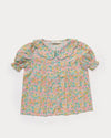 Early Sunday, Camelia Blouse in Emma Floral Mint color, made from printed 60s cotton cambric fabric, featuring short sleeves with peter pan collar, shown in a front flat-lay view
