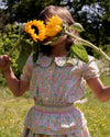 Early Sunday, Camelia Blouse in Emma Floral Mint color, made from printed 60s cotton cambric fabric, featuring short sleeves with peter pan collar, shown in a close up shot of model wearing it.