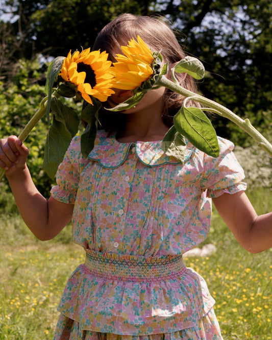 Early Sunday, Camelia Blouse in Emma Floral Mint color, made from printed 60s cotton cambric fabric, featuring short sleeves with peter pan collar, shown in a close up shot of model wearing it.