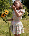 Early Sunday, Camelia Blouse in Emma Floral Mint color, made from printed 60s cotton cambric fabric, featuring short sleeves with peter pan collar, shown in a side view of model wearing it