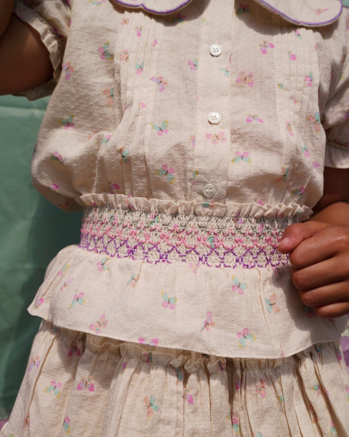 Early Sunday, Camelia Blouse in Butterfly Print color, made from printed cotton tiny swiss dobby fabric, featuring short sleeves with peter pan collar, shown in a close up shot of model wearing it