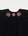Early Sunday, Cara Baby Dress & Bloomer Set in Black, made from Cotton Velvet Velour's fabric, featuring a floral embroidery around the neckline, shown in a closeup flat-lay view