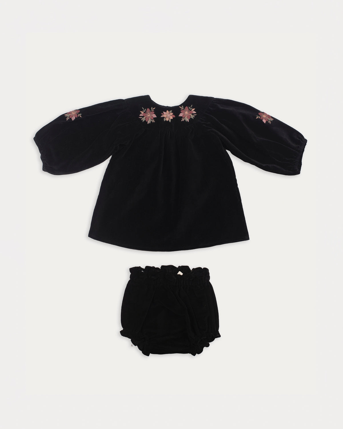 Early Sunday, Cara Baby Dress & Bloomer Set in Black, made from Cotton Velvet Velour's fabric, featuring a floral embroidery around the neckline with matching bloomer, shown in a front flat-lay view