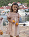 Early Sunday, Caroline Dress in Garden Flowers print, made from Printed Cotton Cambric fabric, featuring tiered silhouette with thoughtful details for a feminine and relaxed look, shown in a front view of model wearing outdoors