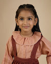 Early Sunday, Cecilia Blouse in Earthy Pink print, made from Cotton Swiss Dobby fabric, featuring relaxed fit, frill neckline, long sleeves with elasticated cuffs, and MOP buttons, shown in a close up shot of model wearing it