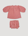 Early Sunday, Charlie Baby Dress & Bloomer Set in Rose color, made from Dyed Cotton Double Gauze fabric, featuring ruffled neckline with floral embroidery & matching bloomers, shown in a back flat-lay view