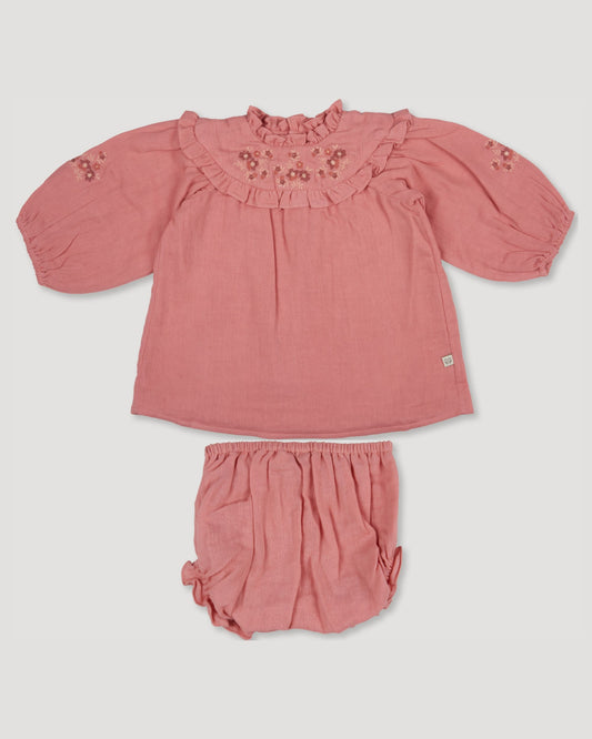 Early Sunday, Charlie Baby Dress & Bloomer Set in Rose color, made from Dyed Cotton Double Gauze fabric, featuring ruffled neckline with floral embroidery & matching bloomers, shown in a front flat-lay view