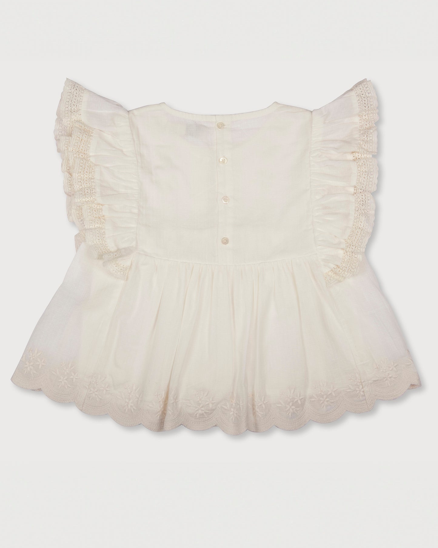 Early Sunday, Charlie Blouse in Ivory print, made from Cotton Tiny Swiss Dots fabric, featuring Flutter sleeves, pintuck detailing, and a flowy, gathered silhouette, shown in a back flat-lay view