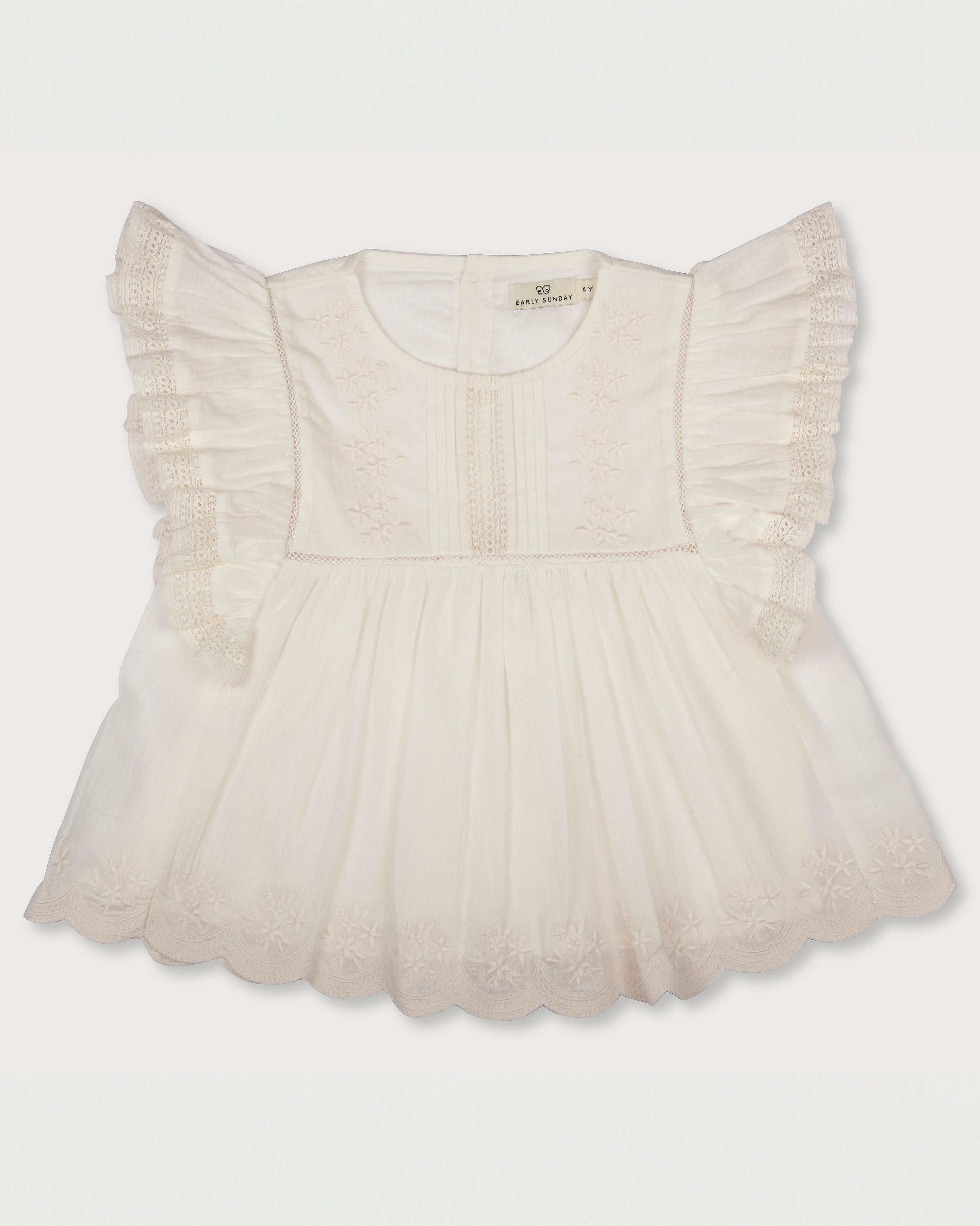Early Sunday, Charlie Blouse in Ivory print, made from Cotton Tiny Swiss Dots fabric, featuring Flutter sleeves, pintuck detailing, and a flowy, gathered silhouette, shown in a front flat-lay view