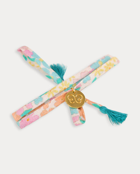 Early Sunday, Charm Bracelet in Emma Floral Mint color, made from Organic Printed Cotton Cambric fabric, featuring a soft fabric bracelet design with a charm, shown in an angled view with a close-up shot