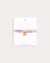 Early Sunday, Charm Bracelet in Emma Floral Purple color, made from Organic Printed Cotton Cambric fabric, featuring a soft fabric bracelet design with a charm, shown in a front flat-lay view