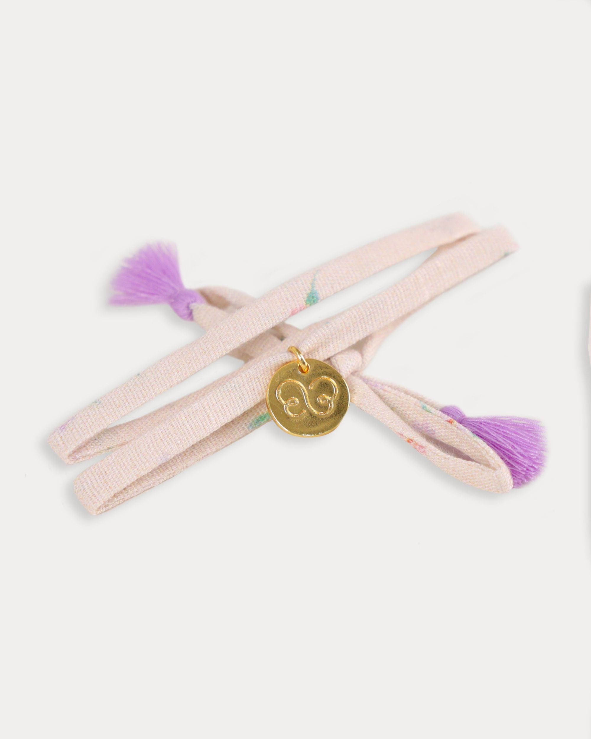 Early Sunday, Charm Bracelet in Painted Bouquet print, made from Printed 70% Cotton, 30% Linen fabric, featuring a soft fabric bracelet design with a charm, shown in an angled view with a close-up shot