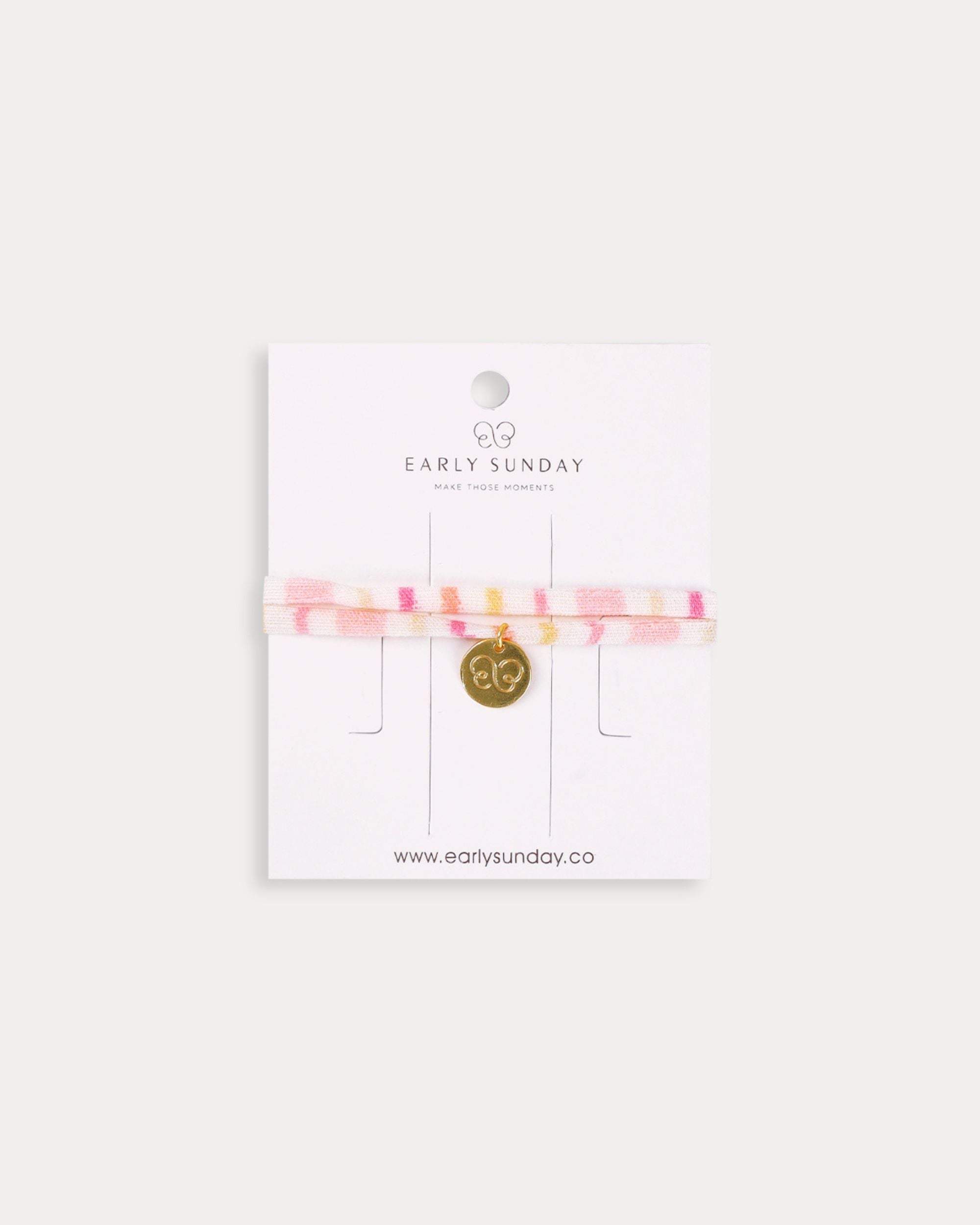 Early Sunday, Charm Bracelet in Pink Stripes print, made from Printed 70% Cotton, 30% Linen fabric, featuring a soft fabric bracelet design with a charm, shown in a front flat-lay view
